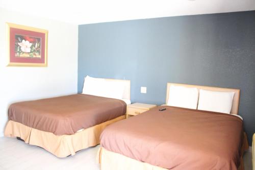 Postel nebo postele na pokoji v ubytování Village Inn Cotulla