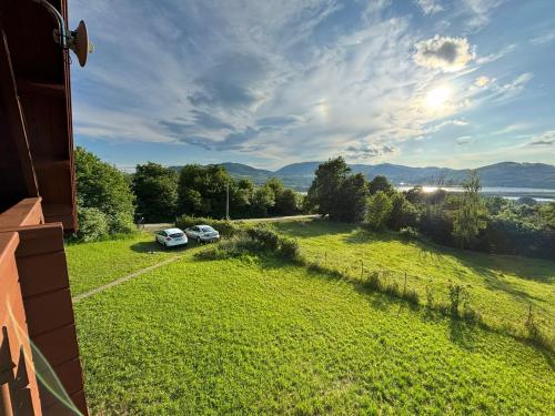 a view of a yard with two cars parked in a field at Domek nad jeziorem Rożnowskim - Gródek Nad Dunajcem in Gródek Nad Dunajcem