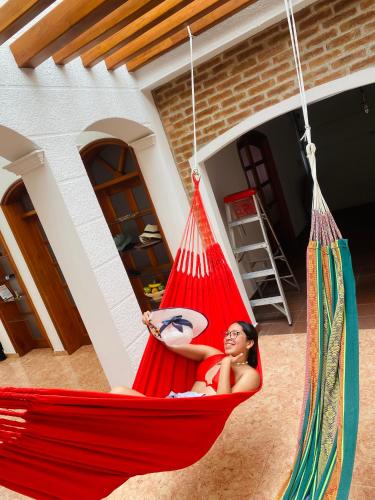 a woman sitting in a hammock in a house at Cartagena Kings Hostel in Cartagena de Indias
