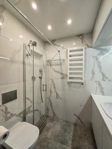une salle de bain avec une douche, des toilettes et un lavabo dans l'établissement Apartament Szymanowskiego 15, à Toruń