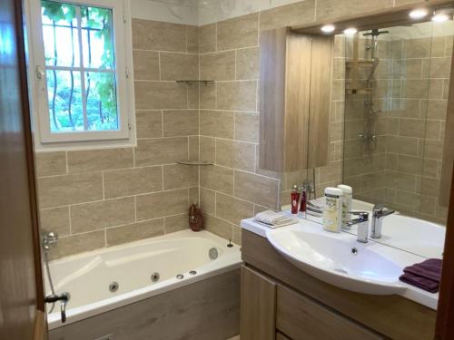 une salle de bain avec une baignoire, un lavabo et une douche dans l'établissement Villa au calme, à Vidauban