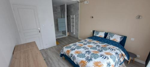 une chambre avec un lit avec une couette bleue et blanche dans l'établissement Charmante maison proche Futuroscope CHU Centre ville, à Buxerolles