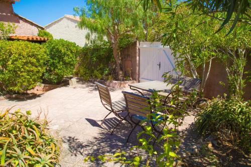 un patio avec un banc, une table et une porte dans l'établissement Villa avec vue de rêve sur la baie d'Ajaccio et les Sanguinaires à Porticcio pour 8 personnes, à Porticcio
