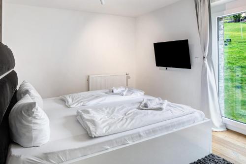 two white beds in a room with a tv at Skylodges in Oberried