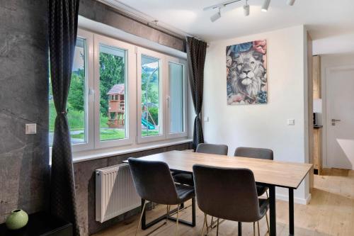 a dining room with a table and chairs and windows at Skylodges in Oberried