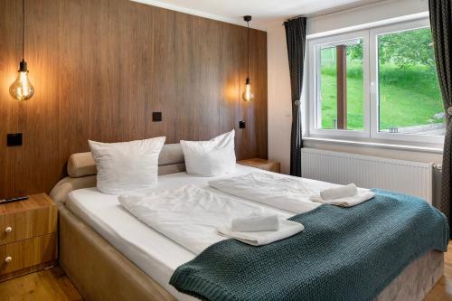 a bedroom with a bed with two towels on it at Skylodges in Oberried