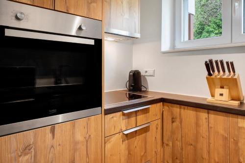a kitchen with wooden cabinets and a black microwave at Skylodges in Oberried