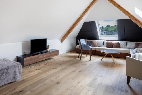 a living room with a couch and a tv at Skylodges in Oberried