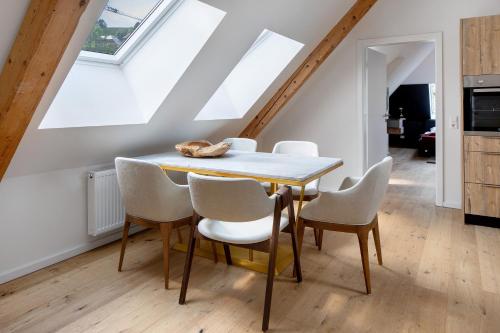 a dining room with a table and white chairs at Skylodges in Oberried