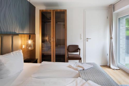 a bedroom with a white bed and a chair at Skylodges in Oberried