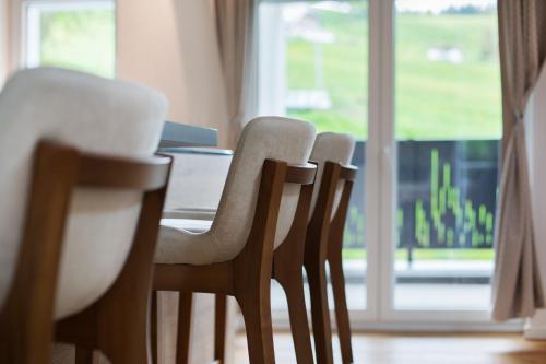 a group of chairs sitting around a table in front of a window at Skylodges in Oberried
