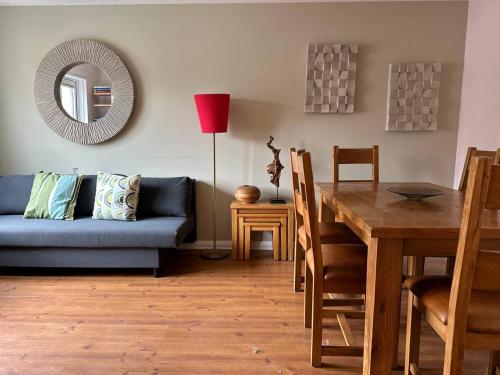 a living room with a blue couch and a table at Beautiful house in Clydebank in Glasgow