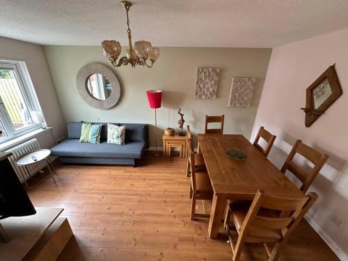 a living room with a table and a blue couch at Beautiful house in Clydebank in Glasgow