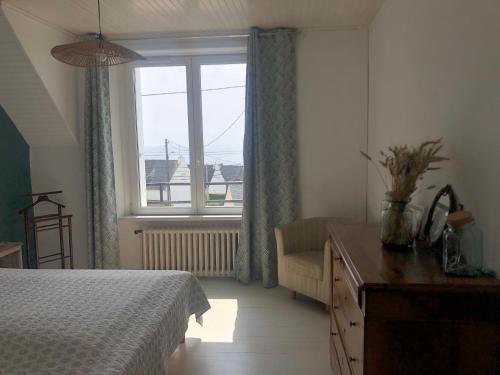 une chambre avec un lit et une fenêtre dans l'établissement Maison de famille vue mer- 4 chambres, 8 personnes, à Plouhinec