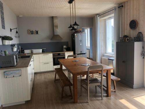 Il comprend une cuisine avec une table en bois et du parquet. dans l'établissement Maison de famille vue mer- 4 chambres, 8 personnes, à Plouhinec