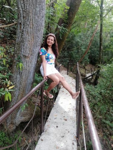a woman is sitting on a fence near a tree at Exclusive Altos del Maria 2 Bedroom Apartment-Private Pool & Mountain Views in Sorá