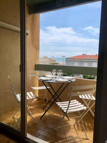 une table et des chaises sur un balcon avec vue dans l'établissement Le Mailheul - Tout compris - vue mer - 160 m de la plage, à Narbonne-Plage