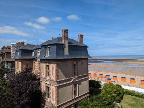 an old house with a roof on the beach at Les Sables d'Or - accès direct plage, vue mer, terrasses, parking in Houlgate