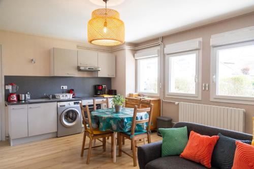 une cuisine et un salon avec une table et des chaises dans l'établissement Le Prunier, à Vals-près-le-Puy