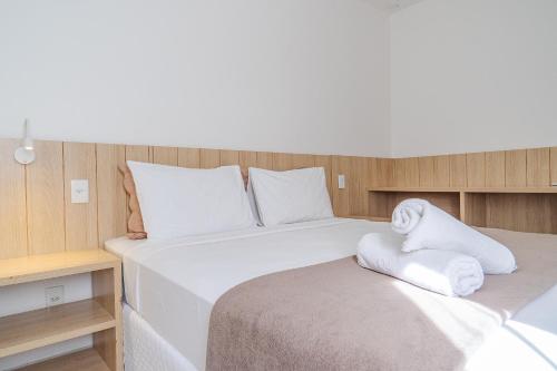 a bedroom with a large bed with white sheets at Pousada Areia do Forte in Cabo Frio