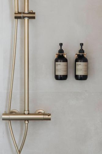 two bottles of soap are hanging on a wall at Foss Lodge - luxe boutique boshuis Veluwe in Nunspeet