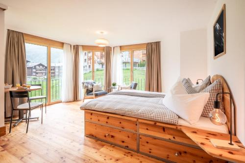 a bedroom with a bed and a table and chairs at Studio Haro in Zermatt