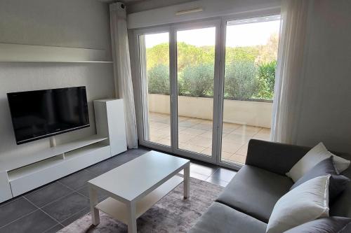 un salon avec un canapé, une télévision et une table dans l'établissement Family apartment 2 Rooms in Antibes, à Antibes