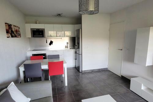une petite cuisine avec une table et des chaises rouges dans l'établissement Family apartment 2 Rooms in Antibes, à Antibes