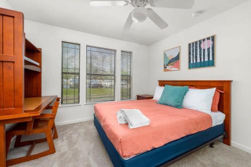a bedroom with a bed and a desk and windows at Family home near USF in Tampa