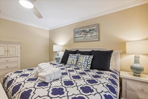 a bedroom with a bed with a blue and white comforter at 2319 Racquet Club in Hilton Head Island
