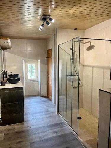 une salle de bain avec une douche en verre dans une chambre dans l'établissement Maison de village avec jardin, à Monpazier