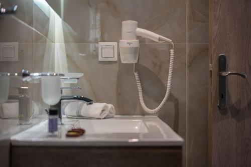a bathroom with a white sink and a phone at Elena's Luxury Sea View House 3 in Neos Marmaras