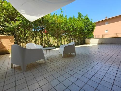 a patio with two white chairs and a table and chairs at Appartamento in centro a Spoleto in Spoleto