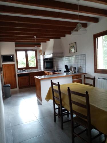 une cuisine avec une table et des chaises dans une pièce dans l'établissement Maison à la campagne, à Duffort