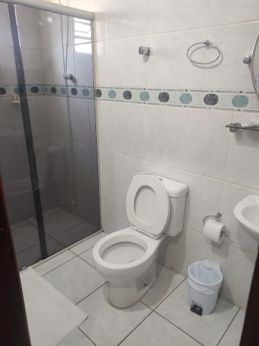 a bathroom with a shower and a toilet and a sink at Hotel Vila Planalto in Brasília