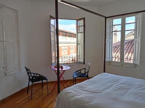 a bedroom with a bed and two chairs and a table at Casa Cañas-Catedral de León in León