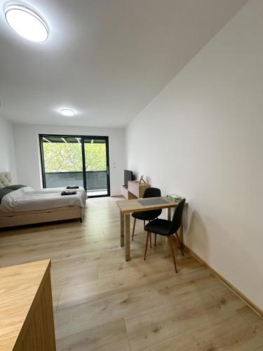 a bedroom with a bed and a desk and a table at DMR APARTMENTS Rosie in Košice