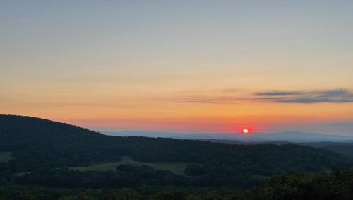 a sunset in the mountains with the sun setting at An Owl's Perch in Morganton