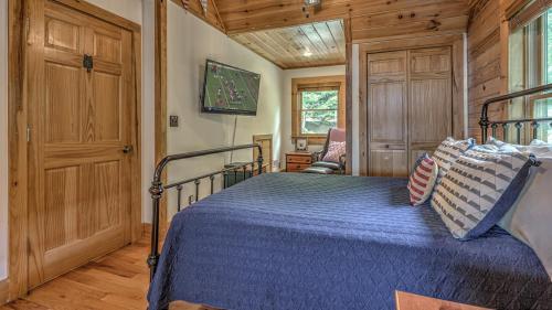 a bedroom with a bed with a blue comforter at An Owl's Perch in Morganton