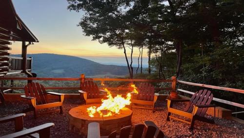 a fire pit with chairs and a table with a view at An Owl's Perch in Morganton