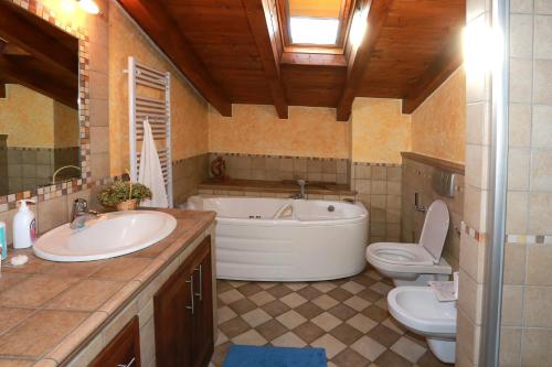 a bathroom with a tub and a sink and a toilet at The Lake Apartment in Colico
