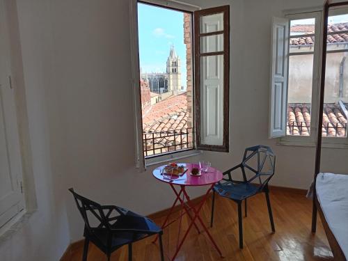 a table and two chairs in a room with a window at Casa Cañas-Catedral de León in León