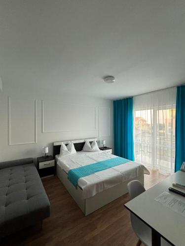 a bedroom with a large bed and a couch at Vila Sofia in Eforie Nord