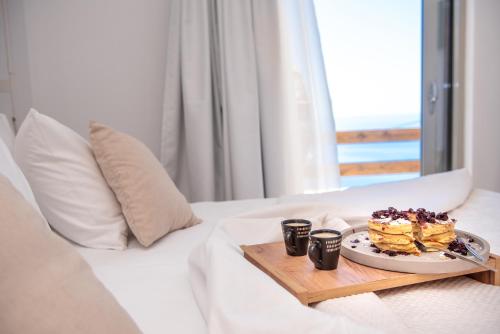 a plate of food on a tray on a bed at Mia Anasa - Luxury Suites in Masouri