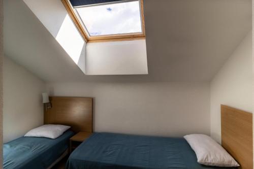 deux lits dans une petite pièce avec une fenêtre dans l'établissement Les Chalets De Bois MÉan - D - Appartement sur les hauteurs des Orres 1800 MAE-9454, aux Orres