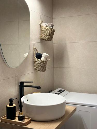 a bathroom with a white sink and a mirror at Villagio Arcadia in Zátouna