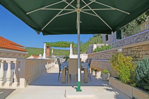 a green umbrella sitting on top of a patio at Relax & Enjoy in Pučišća