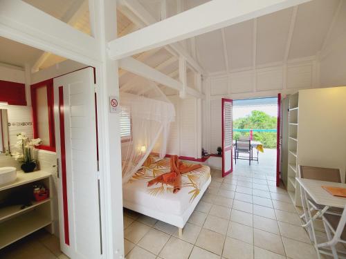 a bedroom with a bunk bed in a room at Pipirite Chantant - Studios Vue Mer in Sainte-Rose
