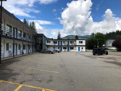 a parking lot with cars parked in front of a building at Revelstoke Lodge in Revelstoke