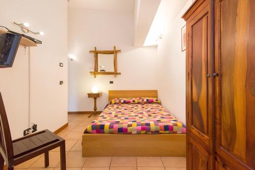 a small bedroom with a bed and a chair at Agriturismo Prisma in Villa Vergano